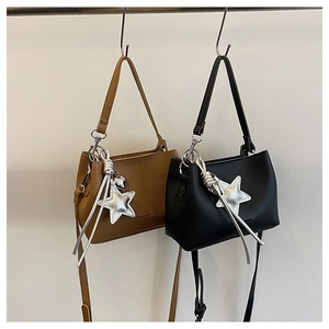 Detail of minimalist bucket bags with silver star charm and lychee grain leather texture