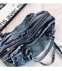 Dettaglio della cerniera in metallo argentato su borsa tote in denim lavato