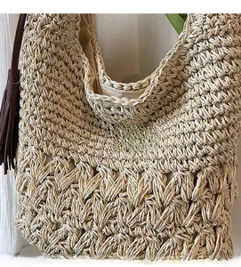 Close-up of woven straw bag texture with brown leather strap and fabric lining details