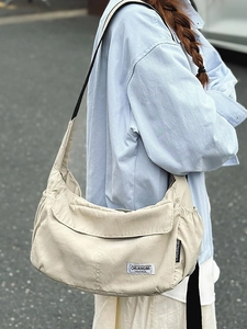 Large capacity off-white nylon hobo bag with adjustable black strap and side pocket
