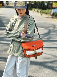 Detail of orange and white nylon messenger bag with colorful chain and shoulder strap