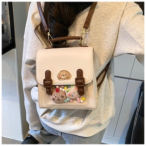 Detailed back view of a beige preppy backpack with brown straps and cute dog embroidery
