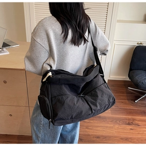 Black nylon tote bag with multiple pockets and natural crinkled texture for daily commuting