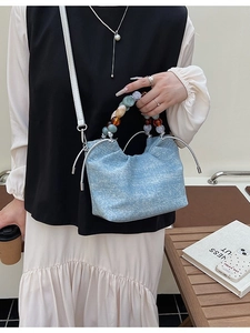 Chic light blue pleated bucket bag with colorful beaded handle and shoulder strap