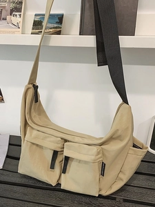Minimalist beige nylon crossbody dumpling bag with dual front pockets and wide strap