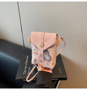 Détail du sac de téléphone rose avec broderie florale et boucle en forme de cœur