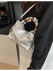 Silver metallic pleated bucket bag with colorful beaded handle and shoulder strap