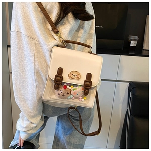 Detail of cream preppy backpack with transparent window and cute plush accessories