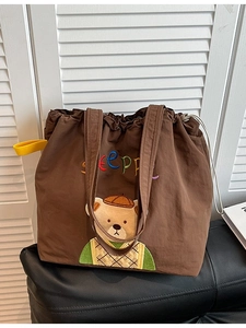 Brown canvas tote bag with cartoon bear embroidery and yellow drawstring strap detail