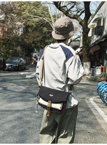 Detail of the durable nylon messenger bag featuring color-blocking and plastic buckle