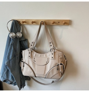 Détail du sac fourre-tout crème avec rivets étoiles Y2K et fermetures éclair en métal
