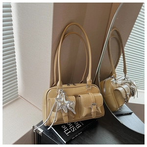 Detail der warmen beige Schultertasche mit Krokoprägung und silbernen Anhängern