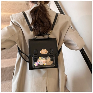 Detail of black PU mini backpack featuring a transparent window with cute plush charms