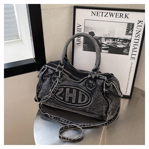 Dettaglio del materiale denim nero lavato e patch logo ZHD sulla borsa shopper chic