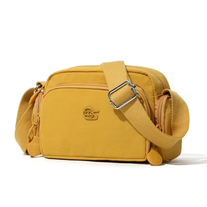 Dettaglio della borsa a tracolla giallo senape in nylon impermeabile con logo