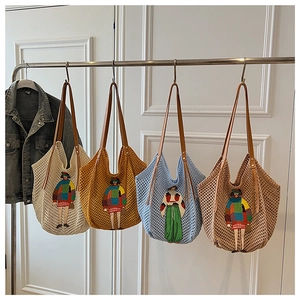 Detailed close-up of colorful artistic embroidery on knit tote bags in four various colors