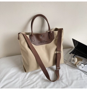 Detail of khaki canvas tote with brown leather trim and detachable shoulder strap