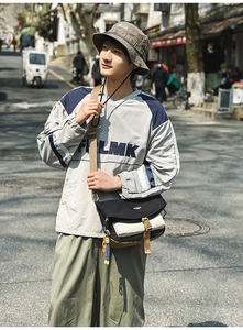 Outdoor leisure style outfit with a two-tone hoodie, khaki pants and crossbody bag