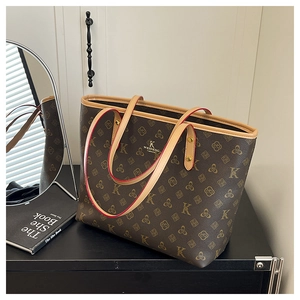 Detailed view of brown monogram tote bag with leather straps on a black shelf
