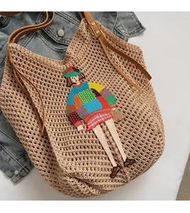 Detail of hand-woven tote bag with colorful cartoon embroidery and leather handles