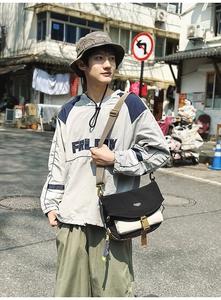 Outdoor street style shot of a nylon crossbody bag with adjustable wide strap and buckle