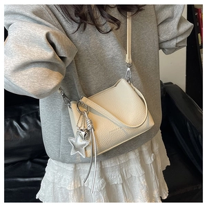 Détail du sac seau crème avec texture lychee et breloques coeur et étoile