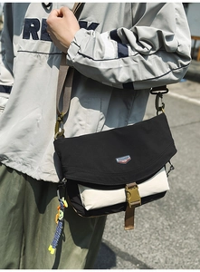 Close-up of contrast nylon messenger bag with buckle closure and woven strap detail