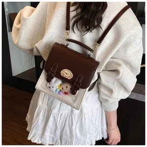 Detail of vintage preppy backpack showing brown leather flap and clear window for plushies