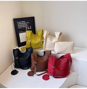 Close-up of pebble leather bucket bags with wide straps and matching inner pouches