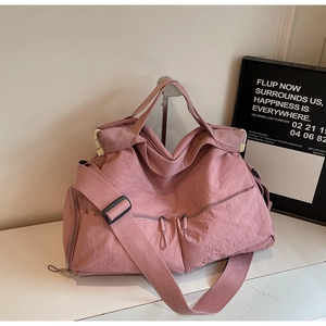Detail of pink nylon multi-pocket travel bag with textured waterproof fabric