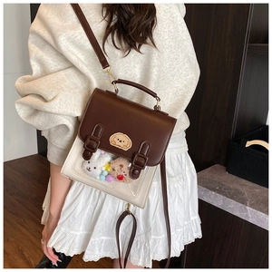 Detail of college style crossbody bag with clear PVC window and plush toy decorations