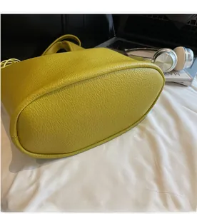 Detail view of the oval bottom and precise stitching on a lime green bucket bag