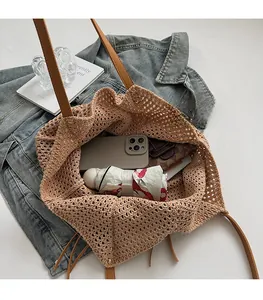 Detail of spacious interior capacity for a knitted tote bag holding phone and umbrella
