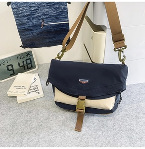 Close-up of contrast nylon crossbody bag with buckle closure and adjustable strap