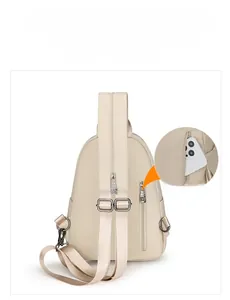 Détail de la poche antivol arrière et de la bandoulière réglable du sac à bandoulière beige