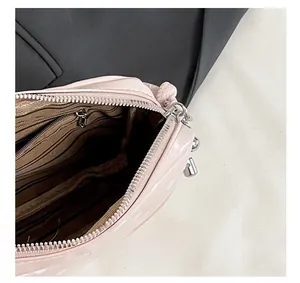 Macro view of pink polka dot bag featuring a metal zipper and striped lining
