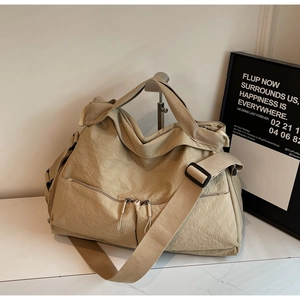 Detail of water-resistant nylon beige travel bag with multiple pockets and shoulder strap