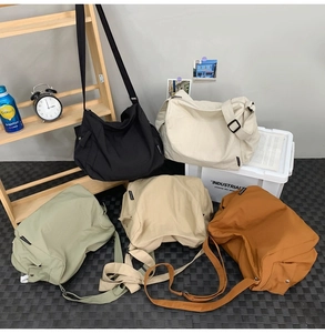 Vue détaillée de grands sacs besaces en toile déclinés en cinq coloris assortis au choix