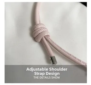 Detail of adjustable pale pink leather shoulder strap with knot and silver metal ends