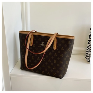 Detailed macro of vintage monogram tote bag with gold lettering and rivet accents