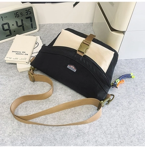 Detail of canvas crossbody bag with buckle closure and stylish woven pendant decoration