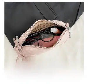 Internal view of pink polka dot crossbody bag showing multiple pockets and storage capacity