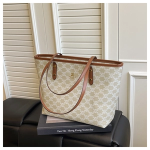 Detailed close-up of a large canvas tote bag with geometric patterns and brown leather trim