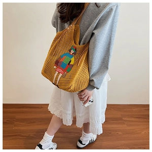 Detailed knit hobo bag with colorful girl embroidery and contrasting brown leather handle