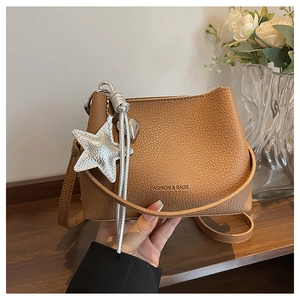 Detail of brown litchi pattern bucket bag with silver star charm and fashion text