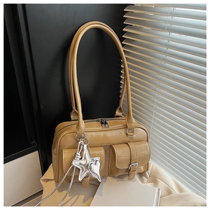 Detail der khakifarbenen Handtasche mit silbernen Stern-Herz-Anhängern und Klapptaschen