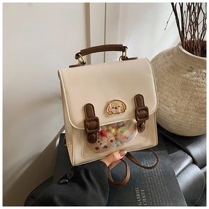 Detail of cream British style backpack featuring clear window and embroidery patch