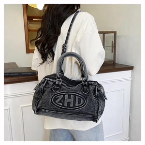 Dettaglio della borsa tote in denim grigio scuro lavato con ricamo ZHD e cerniera in metallo