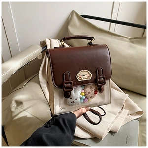 Detail of vintage style crossbody bag with plush charms and transparent window pocket