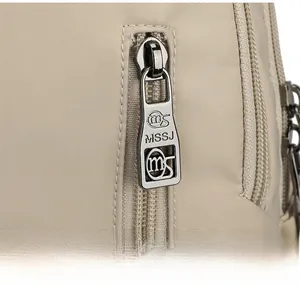 Gros plan sur la fermeture éclair en métal argenté du sac à dos en nylon kaki